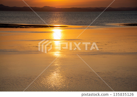 夕陽倒映在平靜的湖面上 135835126