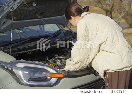 一位女司機的車子出了故障。 一位女司機的車子出了故障。 135835144