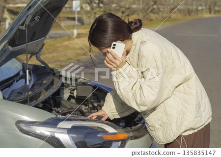 A female driver having trouble with her car 135835147