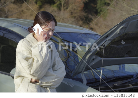 A female driver having trouble with her car 135835148