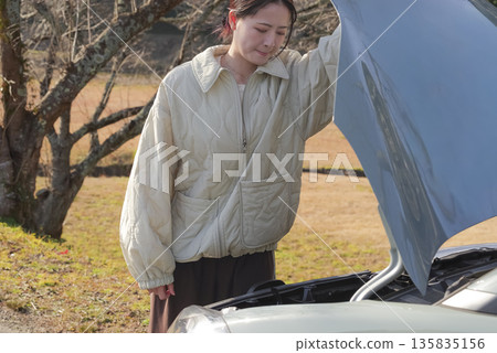 A female driver having trouble with her car A female driver having trouble with her car 135835156