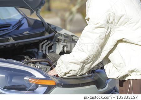A female driver having trouble with her car 135835157