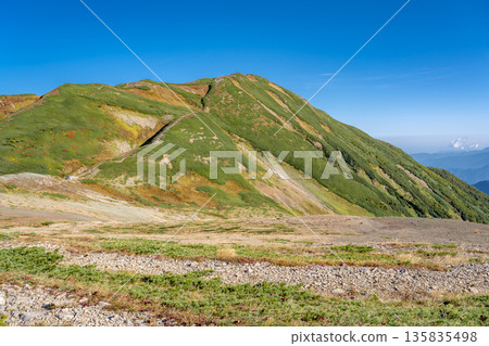 Mt. Yukikura seen from the winding path of Mt. Hachigatake. A traverse from Mt. Hakuba to Mt. Yukikura in the Northern Alps. Mt. Yukikura seen from the winding path of Mt. Hachigatake. A traverse from Mt. Hakuba to Mt. Yukikura in the Northern Alps. 135835498