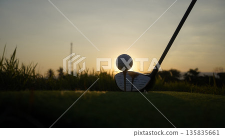 Golf clubs and balls on a green lawn in a beautiful golf course with morning sunshine. 135835661