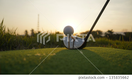 Golf clubs and balls on a green lawn in a beautiful golf course with morning sunshine. 135835662