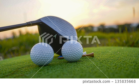 Golf club and golf balls on a green lawn in a beautiful golf course with morning sunshine. 135835668