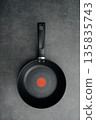 Stainless steel frying pan waiting on a kitchen countertop, ready to be used for cooking, close up 135835743