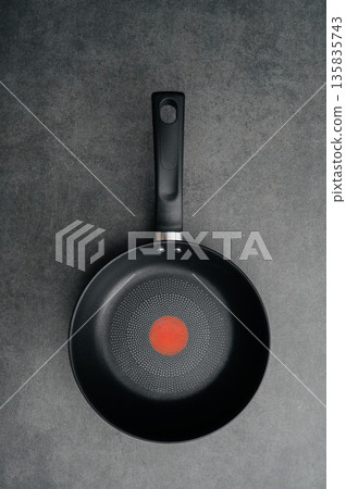 Stainless steel frying pan waiting on a kitchen countertop, ready to be used for cooking, close up 135835743