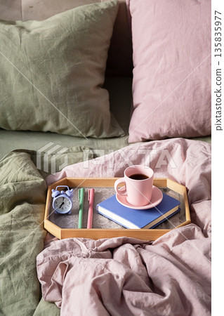 Breakfast in bed, wooden tray with coffee cup, book and alarm clock. Breakfast in bed, wooden tray with coffee cup, book and alarm clock. 135835977