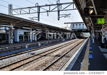 Tsuchiura Station platform on a sunny day and a stopped train 135836077