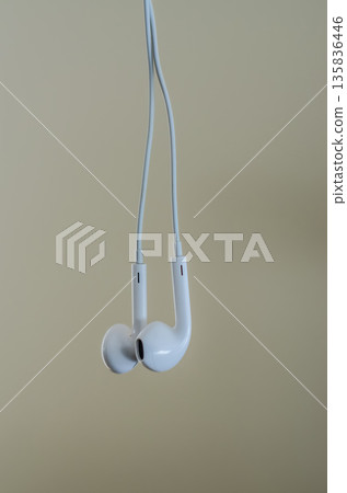 Minimalist composition of classic white wired earbuds. 135836446