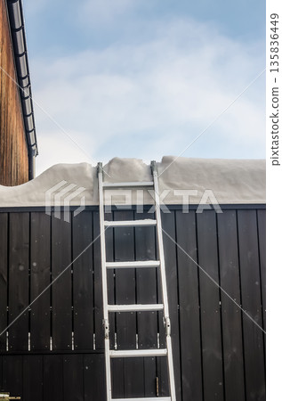 Ladder against a building for rooftop snow removal. Ladder against a building for rooftop snow removal. 135836449