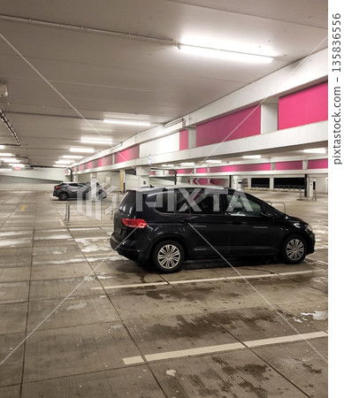 A modern black crossover in a half-empty indoor parking lot of a shopping center A modern black crossover in a half-empty indoor parking lot of a shopping center 135836556