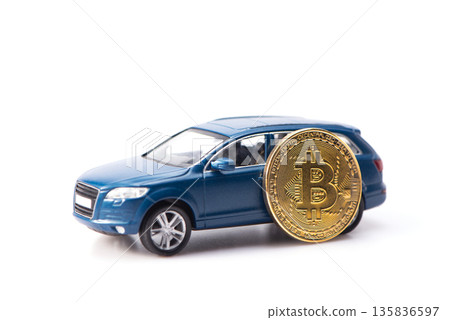 Blue toy car with a golden bitcoin coin isolated on white. Concept of buying a car with cryptocurrency. Blue toy car with a golden bitcoin coin isolated on white. Concept of buying a car with cryptocurrency. 135836597