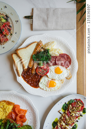 Breakfast plate with eggs sausages and beans Breakfast plate with eggs sausages and beans 135836897