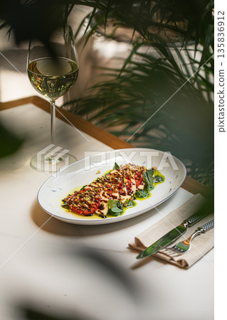 Caprese salad served with white wine and shadows 135836912