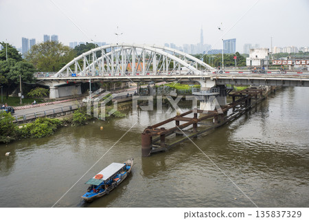 Boat is floating on a river near a bridge 135837329