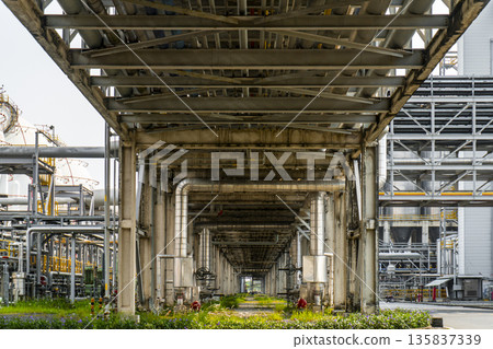 Long, empty industrial building with a large, open space in the middle Long, empty industrial building with a large, open space in the middle 135837339