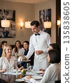 Professional Male Waiter Serving Gourmet Food to a Group of Smiling Women in a High-End Restaurant, Fine Dining Experience with Beautiful Natural Light and Elegant Table Setting. 135838605