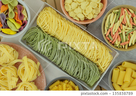 Variety of multi colored pasta. Types of uncooked pasta. Pattern of italian gastronomy. Homemade traditional pasta. Top view. Variety of multi colored pasta. Types of uncooked pasta. Pattern of italian gastronomy. Homemade traditional pasta. Top view. 135838789