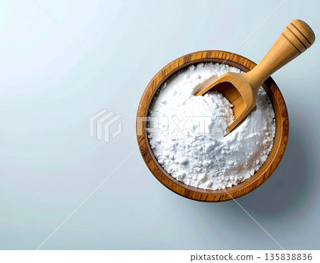 Nontoxic cleaning. Pile of powdered detergent in a wooden bowl with a wooden spoon on a white background. Baking soda. Nontoxic cleaning. Pile of powdered detergent in a wooden bowl with a wooden spoon on a white background. Baking soda. 135838836