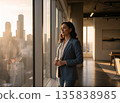 Confident Middle-Aged Businesswoman Standing by Office Window Overlooking City Skyscrapers at Sunset, Visionary Leadership and Career Success Concept with Warm Golden Hour Lighting. 135838985