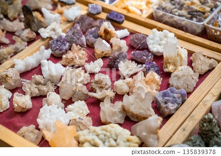 Stall filled with various precious and semi precious stones and crystals Altai Russia. Colorful collection of natural minerals for sale and display. 135839378