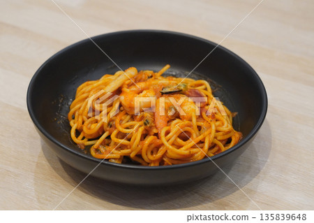hot spaghetti with seafood, shrimp, tomato ketchup, cockles in a black ceramic bowl, on wooden floor background, food, object, copy space hot spaghetti with seafood, shrimp, tomato ketchup, cockles in a black ceramic bowl, on wooden floor background, food, object, copy space 135839648