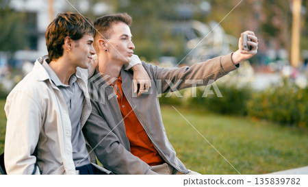 Gay couple taking selfie in a city park Gay couple taking selfie in a city park 135839782