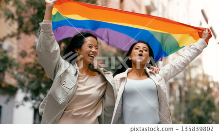 Diverse women celebrating pride, holding rainbow flag 135839802