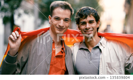 Gay couple celebrating pride with rainbow flag Gay couple celebrating pride with rainbow flag 135839804