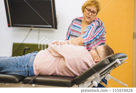Physical therapist helping person with disability during recovery 135839826
