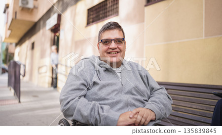 Smiling man sitting in wheelchair outdoors Smiling man sitting in wheelchair outdoors 135839845