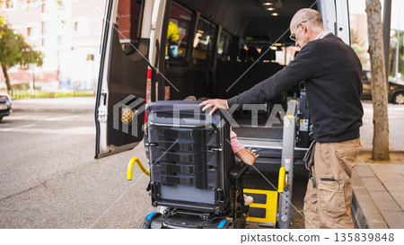 Man helping person with disability onto accessible van 135839848