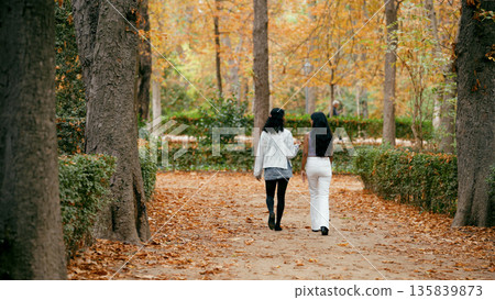 Indian women walking and talking in autumn park 135839873