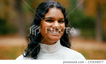 Indian woman smiling outdoors during autumn 135839877