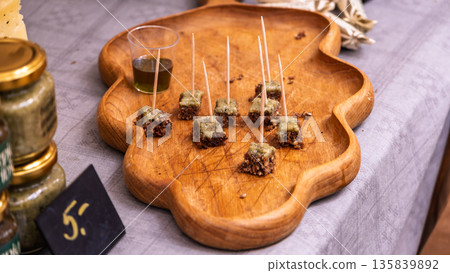 Small appetizer bites on wooden tasting platter Small appetizer bites on wooden tasting platter 135839892