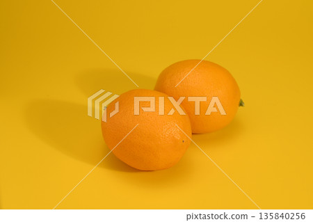 Two lemons on a yellow background Two lemons on a yellow background 135840256