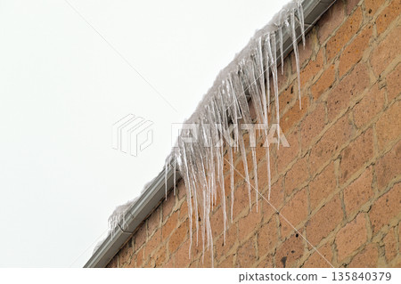 A brick wall covered in icicles 135840379