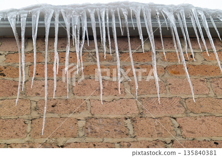A brick wall covered in icicles 135840381