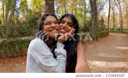 Indian women smiling taking selfie in autumn park 135840387
