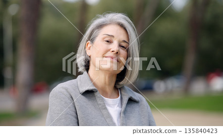 Mature woman smiling, expressing confidence and aging gracefully 135840423