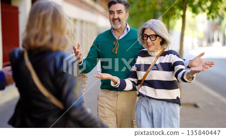 Senior friends greeting on street during happy reunion Senior friends greeting on street during happy reunion 135840447
