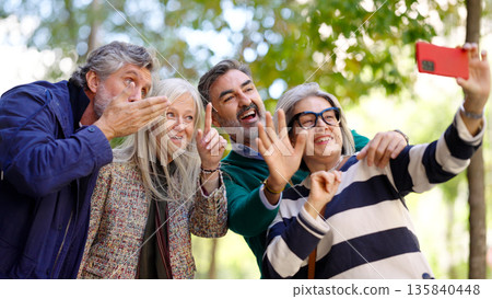 Older friends taking a cheerful outdoor selfie Older friends taking a cheerful outdoor selfie 135840448