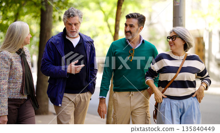 Group of senior friends walking and talking Group of senior friends walking and talking 135840449