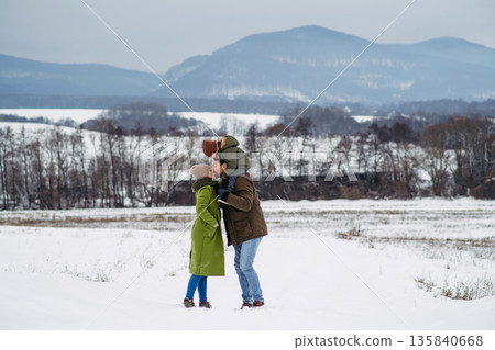 Father, mother and young son on walk in winter nature. 135840668