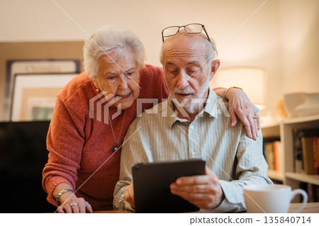 Elderly couple enjoying technology and spending time together. Elderly couple enjoying technology and spending time together. 135840714