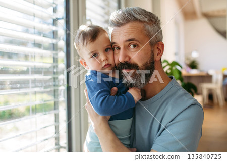 Dad holding his little toddler son in arms. Dad holding his little toddler son in arms. 135840725