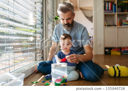 Father playing with little son with toys. Father playing with little son with toys. 135840726