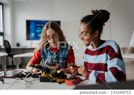 High school students working on robotics project, using online AI app to answer questions. High school students working on robotics project, using online AI app to answer questions. 135840752